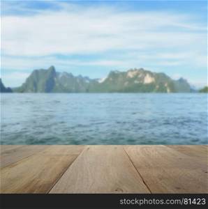 wood table top on blurred beautiful landscape with mountain and lake
