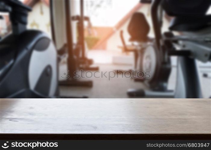 wood table with background of fitness room club interior for montage or display your product