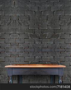 wood table with black brick wall