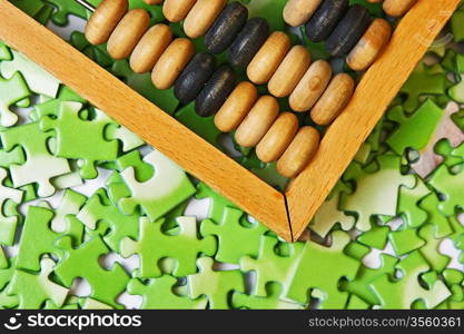 wooden abacus on pile of green puzzle