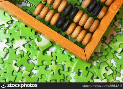 wooden abacus on pile of green puzzle