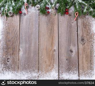 Wooden background for Christmas concept with fir branches covered in snow. Overhead view with copy space.