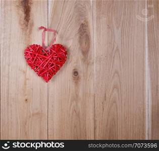 wooden background of oak boards and a red wicker heart, copy space