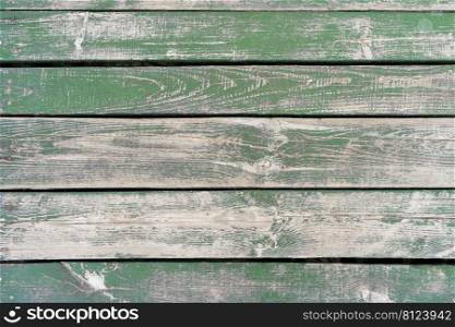 Wooden background. Old green painted wooden plank surface, aged weathered cracked boards. Grunge shabby texture.. Green weathered aged wooden background