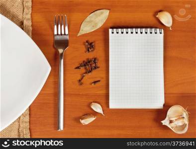 Wooden background with a plate with a fork and spices