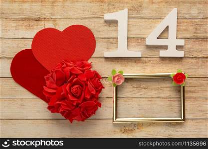 Wooden background with flowers, hearts, frame and wooden numbers of dated 14 February. The concept of Valentine Day.