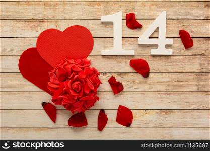 Wooden background with petals, flowers, hearts and wooden numbers of dated 14 February. The concept of Valentine Day.