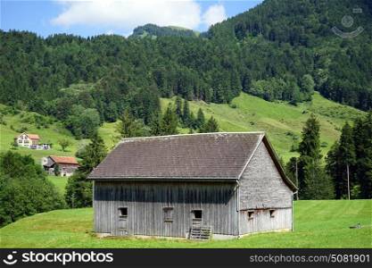 Wooden barn on the farm field in Switzerland