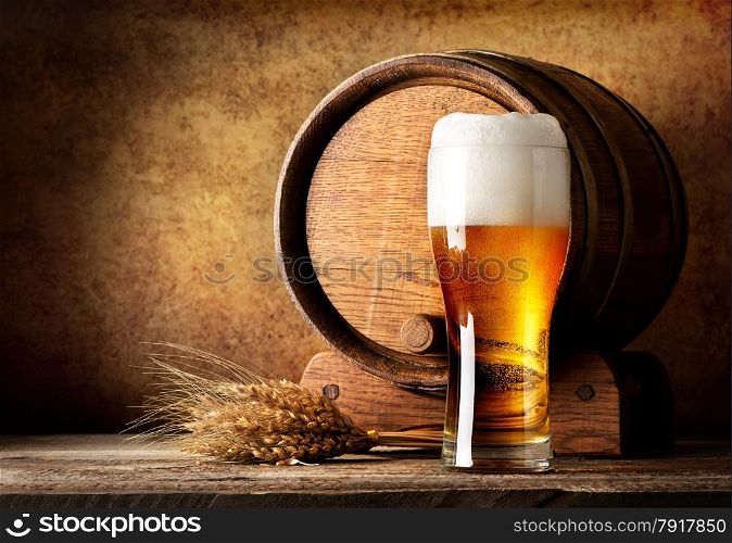 Wooden barrel and beer with wheat on a wooden table