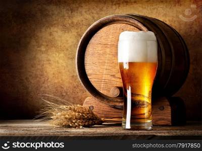 Wooden barrel and beer with wheat on a wooden table