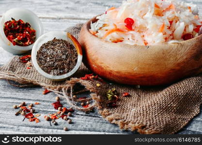 Wooden barrel of sauerkraut and spices on burlap. Sauerkraut with cranberries