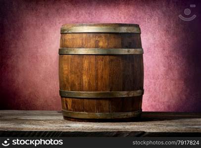 Wooden barrel on a table and pink background