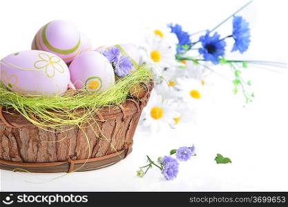 wooden basket of easter eggs with wildflowers