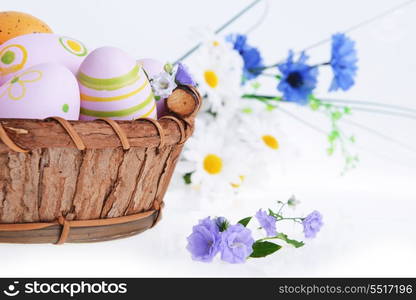 wooden basket of easter eggs with wildflowers