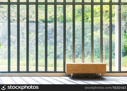 Wooden bench in front of French window with sunlight and countryside view