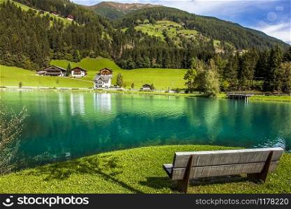 Wooden bench in front of the Muhlwald reservoir in Muhlwald South Tyrol Italy