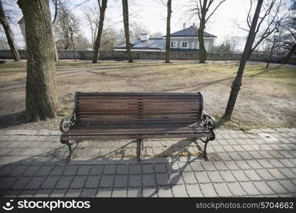 Wooden bench on path in park; Tallinn; Estonia; Europe