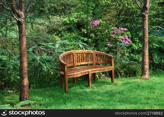 wooden bench standing in a beautiful garden