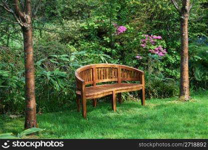 wooden bench standing in a beautiful garden