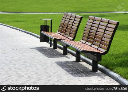 Wooden benches against the background of green grass