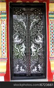 Wooden black laquer door of buddhist templewat Klong Prao, Ko Chang island, Thailand