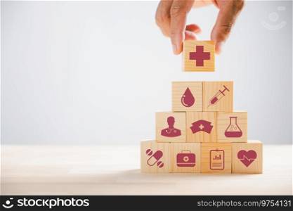 Wooden block held by hand, displaying healthcare and medical icons. Portrays safety, health, and family well-being, symbolizing pharmacy, heart care, and happiness. health care concept