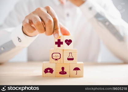 Wooden block held by hand features healthcare and medical icons, portraying safety, health, and family well-being. Reflecting pharmacy, heart care, and happiness. health care concept
