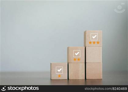 wooden block in review concept Survey and Assessment Concept The wooden blocks are arranged in a pyramid. cube with check mark icon on wooden block Gray background with copy space