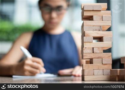 wooden block tower with Businesswoman background. Business planning, Risk Management, Solution and strategy Concepts