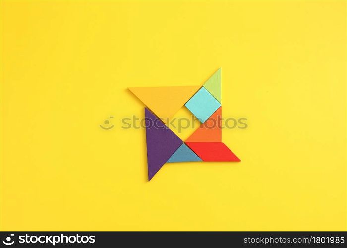Wooden blocks windmill isolated in yellow background