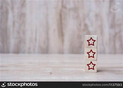 wooden blocks with the three star symbol. Customer reviews, feedback, rating, ranking and service concept.