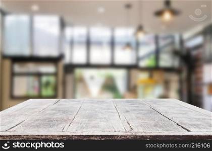 Wooden board empty Table Top And Blur Interior over blur in coffee shop Background, Mock up for display of product.