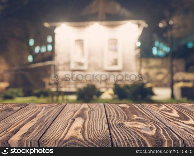 Wooden board empty table top on of blurred background. Perspective brown wood table over blur in coffee shop background - can be used mock up for montage products display or design key visual layout.. empty wooden table front blurred house backdrop
