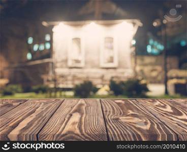 Wooden board empty table top on of blurred background. Perspective brown wood table over blur in coffee shop background - can be used mock up for montage products display or design key visual layout.. empty wooden table front blurred house backdrop