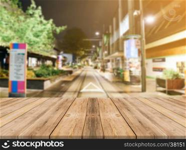 Wooden board empty table top on of blurred background. Perspective brown wood table over blur in street city night background - can be used mock up for montage products display or design visual layout