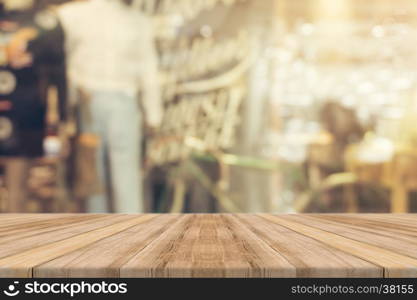 Wooden board empty table top on of blurred background. Perspective brown wood table over blur in coffee shop background - can be used mock up for montage products display or design key visual layout.