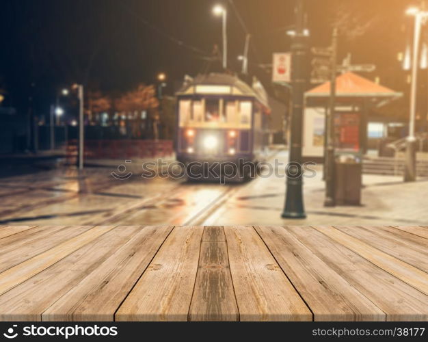 Wooden board empty table top on of blurred background. Perspective brown wood table over blur in street city night background - can be used mock up for montage products display or design visual layout