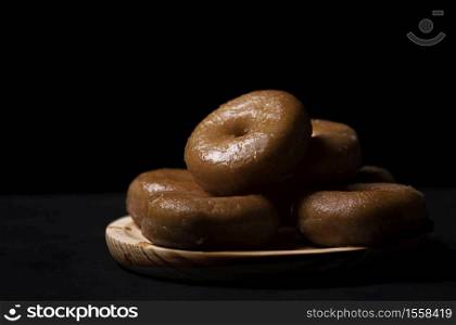 wooden board with doughnuts on a black background
