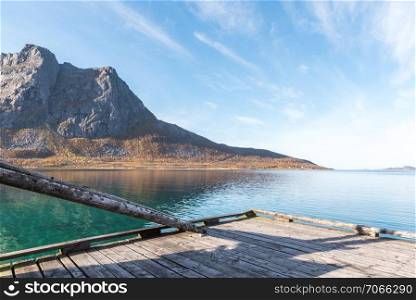 Wooden Boardwalk Jetty Pier with Still Ocean Water with Mountains in Background