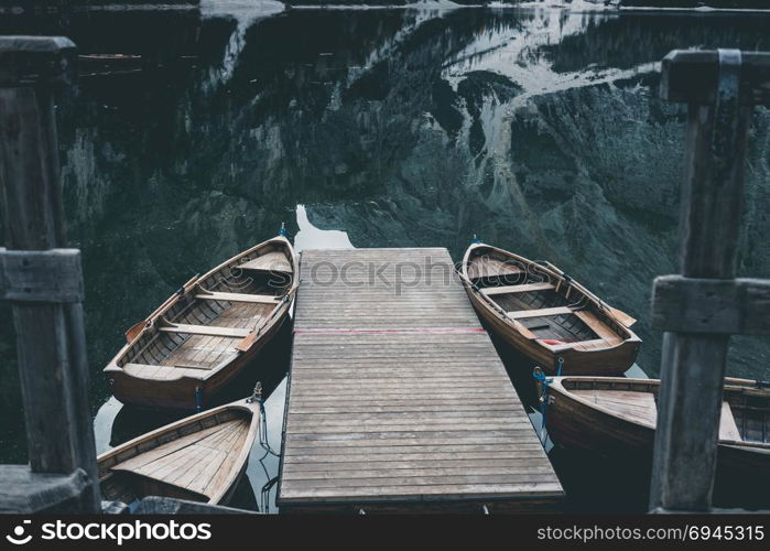 Wooden boats at the Alpine mountain lake. Braies lake, Dolomites, Italy.