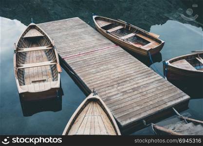 Wooden boats at the Alpine mountain lake. Braies lake, Dolomites, Italy.