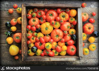 Wooden box filled with fresh vine ripened heirloom tomatoes from farmers market