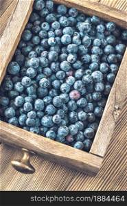 Wooden box of fresh blueberries on wooden table