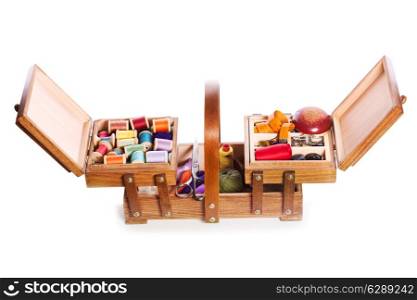 wooden box with scissors, various threads and sewing tools on white background