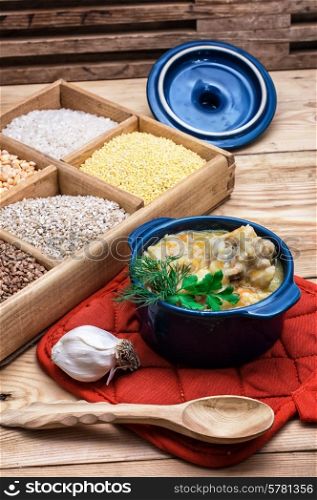 wooden box with varieties of cereals on the background of the cooked pilaf.. Uzbek pilaf