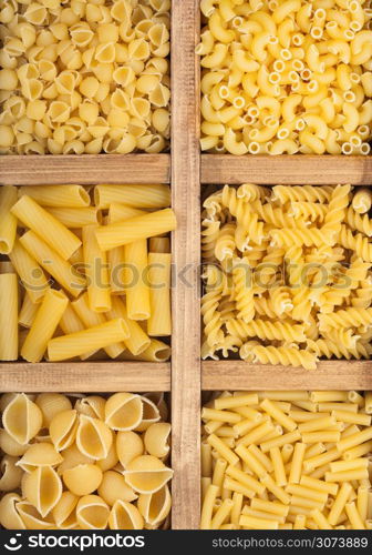 Wooden box with various fresh raw classic pasta. Top view