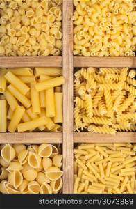 Wooden box with various fresh raw classic pasta. Top view