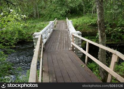 Wooden bridge across the river in the forest of Karelia