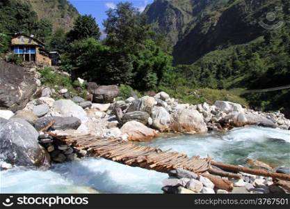 Wooden bridge and river in village in Nepal
