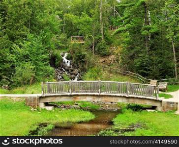 wooden bridge and small waterfall in the park